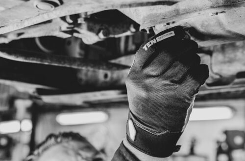 a black and white photo of a man working on a vehicle
